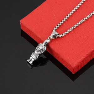 Macro shot of silver terracotta warrior pendant on a stainless steel chain over a red box