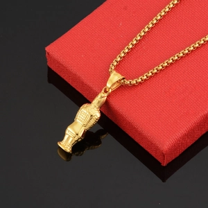 Macro shot of gold terracotta warrior pendant with textured armor on a sturdy box chain