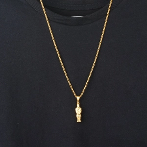 Golden terracotta warrior pendant on box chain worn over a stylish black t-shirt