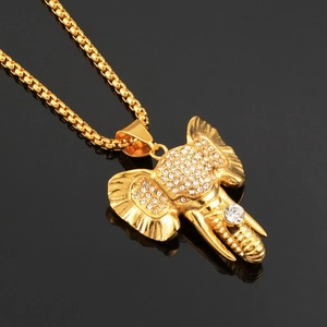 Vue macro du pendentif éléphant hip-hop plaqué or avec cristaux blancs sur fond noir