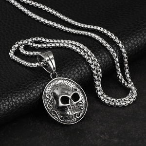 Hip hop titanium steel necklace with 3D skull relief pendant on black leather background