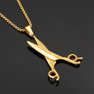 Detailed view of the golden scissor pendant with textured grid handle on a box chain