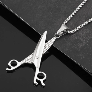Detailed close-up of silver scissors pendant with grid pattern and box chain necklace