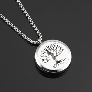 Detailed close-up of tree of life engraving on a round stainless steel pendant necklace