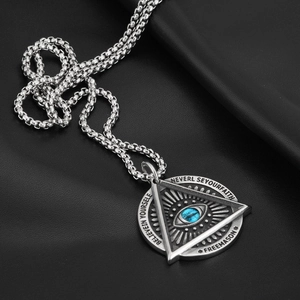 Detailed macro view of silver Freemason evil eye pendant on black leather background