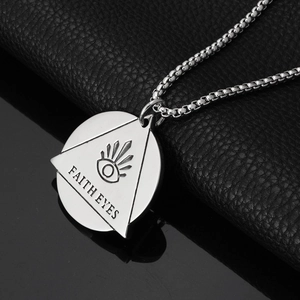 Macro shot of stainless steel triangle pendant with Faith Eyes and bead chain