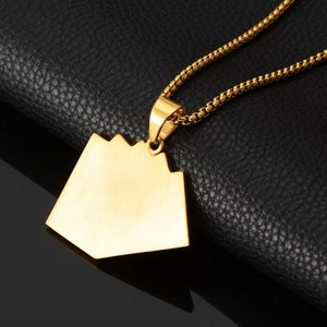 Macro shot of gold geometric irregular pentagon pendant with stylish bead chain link
