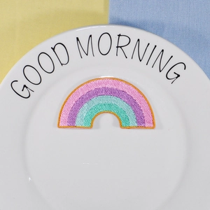 Rainbow embroidered patch accessory on white ceramic plate with colorful background