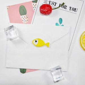 Mini yellow fish embroidery patch on white envelope with elegant artistic decorations