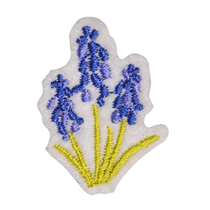 Blue and purple floral embroidery patch with green stems on a white felt background
