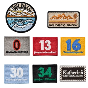 Various embroidered number and nature themed patches with detailed stitching and white border