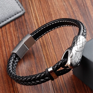 Detail of black braided leather bracelet featuring a silver snake head and magnetic clasp
