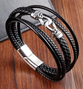 Détail du bracelet en cuir tressé pour hommes avec crochet en métal argenté gravé sur bois