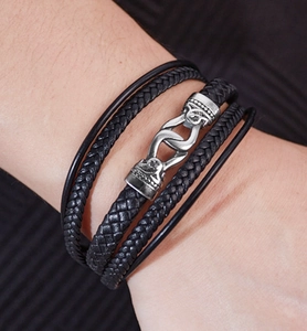 Gros plan sur le bracelet en cuir tressé multicouche noir avec fermoir vintage en argent