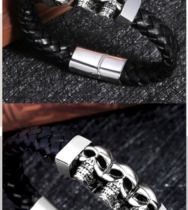 Detail of magnetic clasp and silver skull charms on black braided leather bracelet
