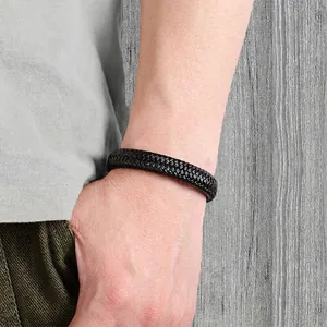 Men's minimalist black braided leather bracelet with stainless steel clasp on wrist