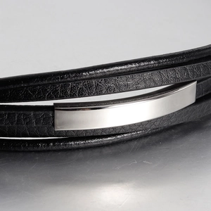 Macro detail of men's multi-layer black leather bracelet with polished silver metal insert