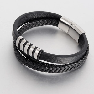 Macro shot of multi-layer black braided leather bracelet with polished silver metal buckle