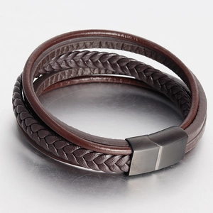 Detail showing multilayer dark brown braided leather straps and matte black magnetic clasp