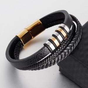 Macro detail of men's leather bracelet showing woven layers and magnetic gold clasp