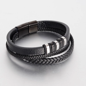 Macro view of multi-layer braided leather bracelet with metallic ring accents and clasp