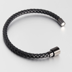 Macro detail of men's braided leather bracelet with polished magnetic steel clasp