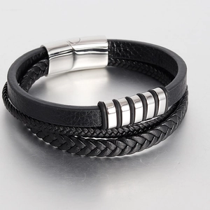 Detail of multi-layer black braided leather bracelet with polished silver metal rings