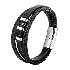 Macro detail of multi-layer black leather bracelet with steel magnetic clasp and metal rings