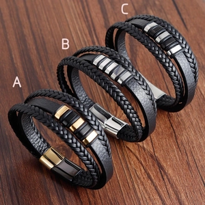 Multi-layer braided leather bracelet for men with magnetic metal clasp on wood surface