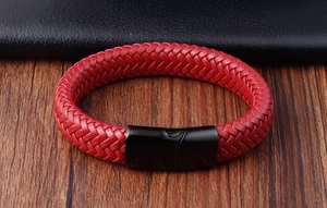Red braided leather bracelet with black magnetic metal clasp on a textured background