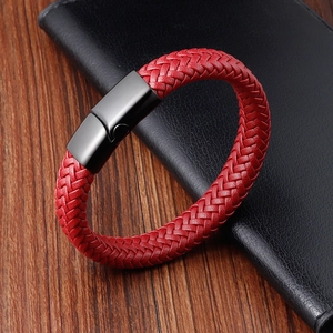 Red braided leather bracelet with black matte magnetic metal clasp on wooden background