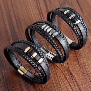 Detail of three men's multi-layer woven leather bracelets with stainless steel magnetic clasps
