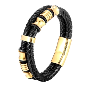 Dettaglio del bracciale doppio in pelle nera intrecciata con chiusura dorata