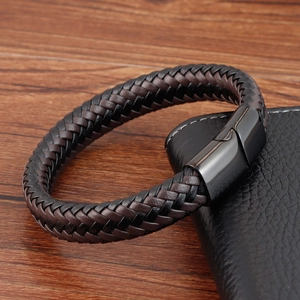 Détail du bracelet tressé en cuir noir et marron foncé avec fermoir magnétique en métal
