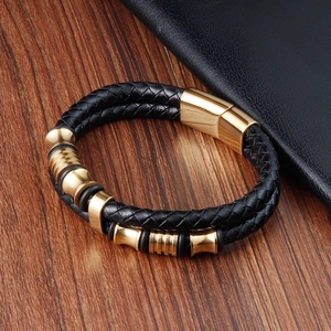 Dettaglio del bracciale in pelle intrecciata a doppio strato nero con perline dorate
