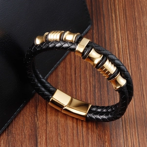 Dettaglio del bracciale da uomo in pelle nera intrecciata con accenti dorati lucidi