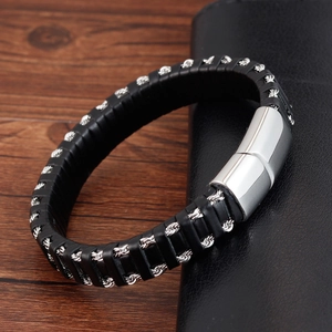 Braided black leather men's bracelet with silver metal magnetic clasp on a desk