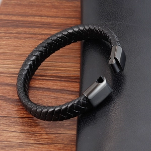 Men's braided black leather bracelet with gunmetal magnetic clasp on wood surface