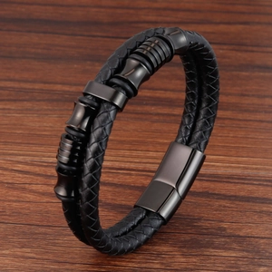 Dettaglio del bracciale a doppio strato in pelle nera intrecciata con chiusura magnetica