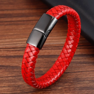 Macro shot of red braided leather bracelet with matte black magnetic clasp on wood