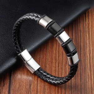 Detail view of woven black leather bracelet with silver and black magnetic metal clasp