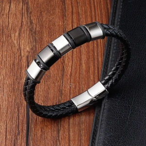 Detail of men's black braided leather bracelet featuring steel beads and magnetic clasp