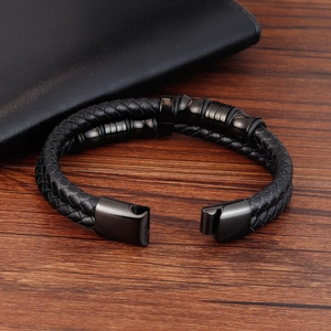 Dettaglio del bracciale a doppio strato in pelle nera intrecciata con chiusura magnetica