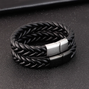 Détail de bracelets en cuir tressé noir avec fermoirs magnétiques argent et noir