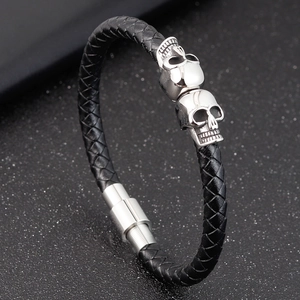 Men's punk braided leather bracelet featuring silver metal skull charms and magnetic clasp