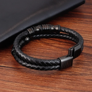 Dettaglio del bracciale a doppio strato in pelle nera intrecciata con chiusura magnetica