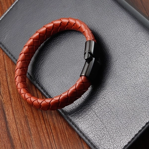 Detail of tan braided leather men's bracelet with a sleek black magnetic clasp closure