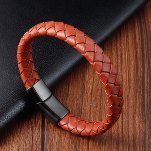 Detailed close-up of the orange braided leather strap with a black brushed magnetic buckle