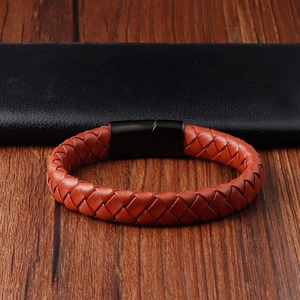 Detail of red-brown braided leather bracelet with black matte magnetic buckle