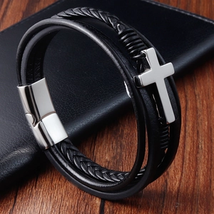 Close-up of multilayer black braided leather bracelet with silver cross and magnetic clasp